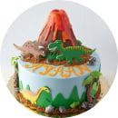 A cake decorated with dinosaurs and a volcano design, perfect for a dinosaur-themed party.